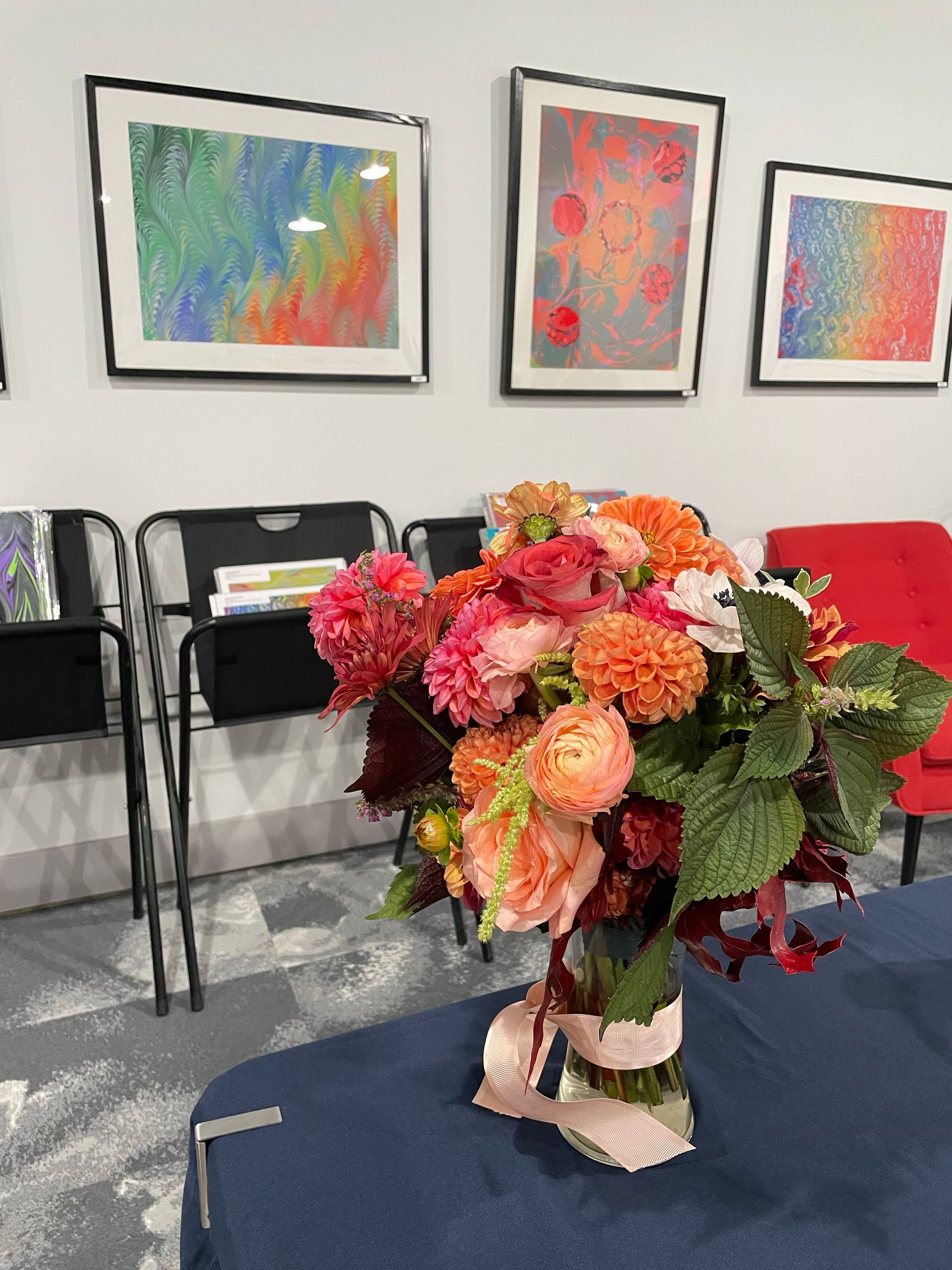 Photo of flowers and rainbow colored artworks in the gallery and lounge at Whistling Studios.