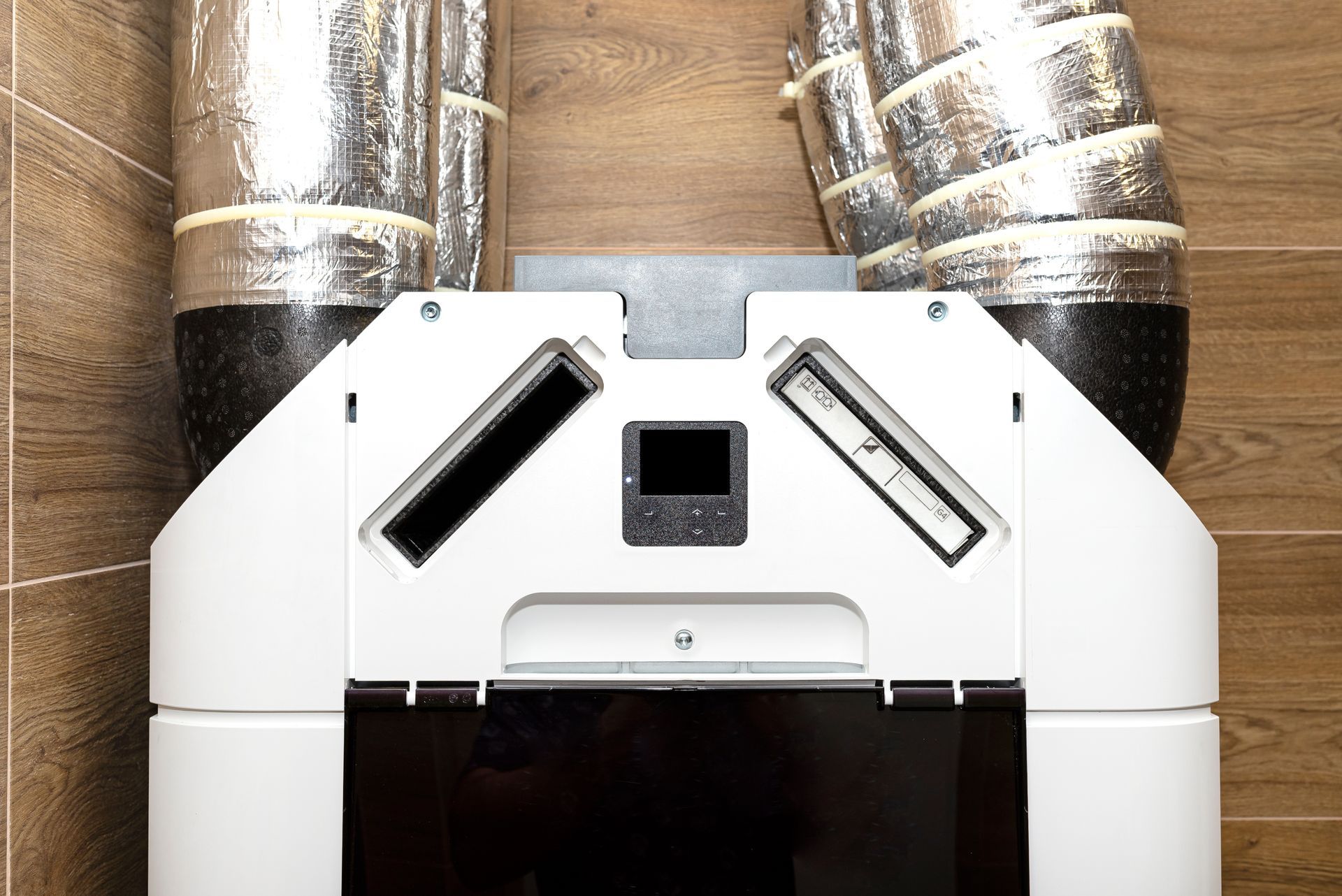 A white air conditioner is hanging on a wooden wall.