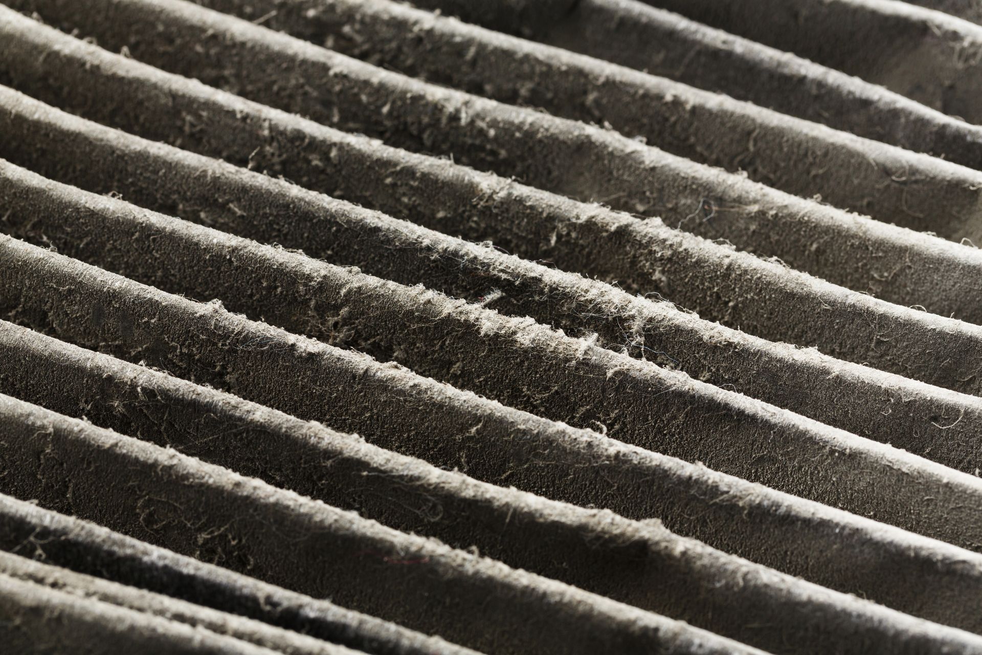 A close up of a dirty air filter with a lot of dust on it.