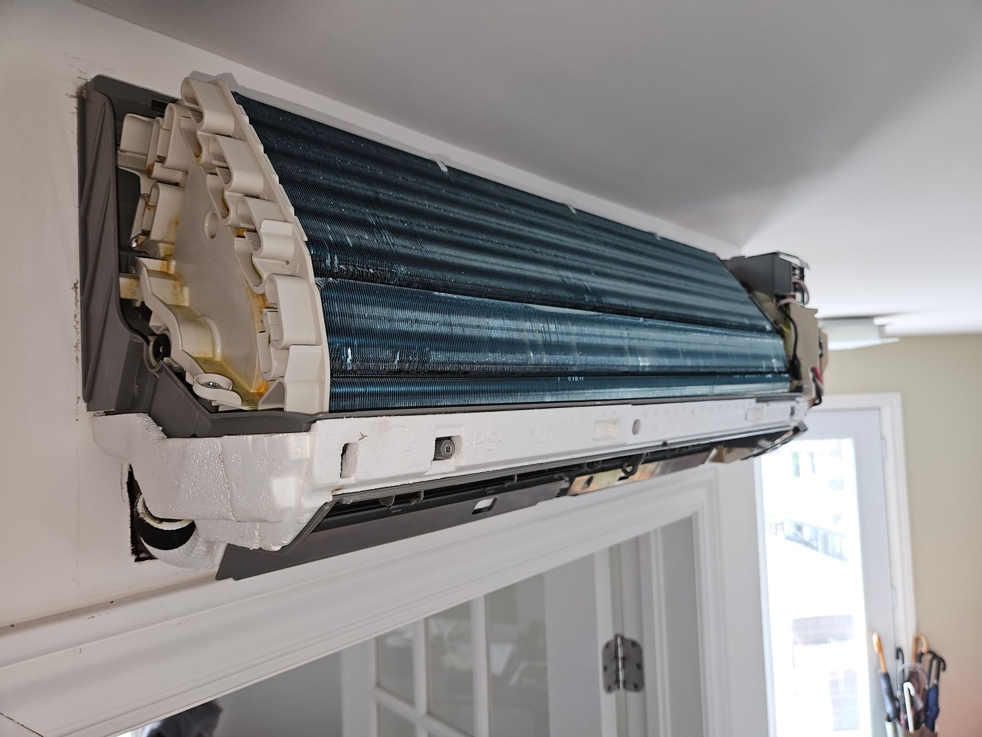 A close up of an air conditioner on a wall in a room.