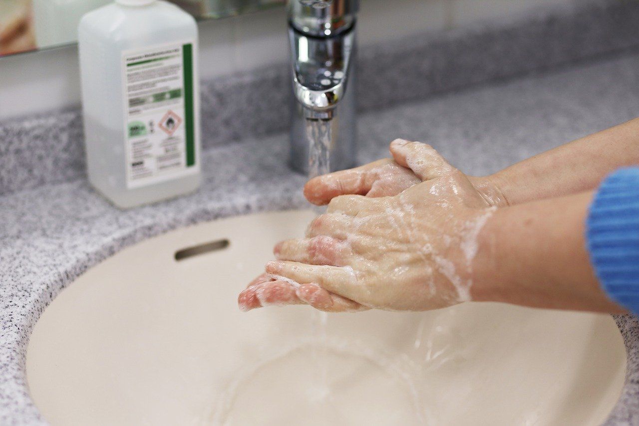 An individual in a commercial property washes their hands at an office sink. Some commercial buildings still rely on septic systems for their buildings.