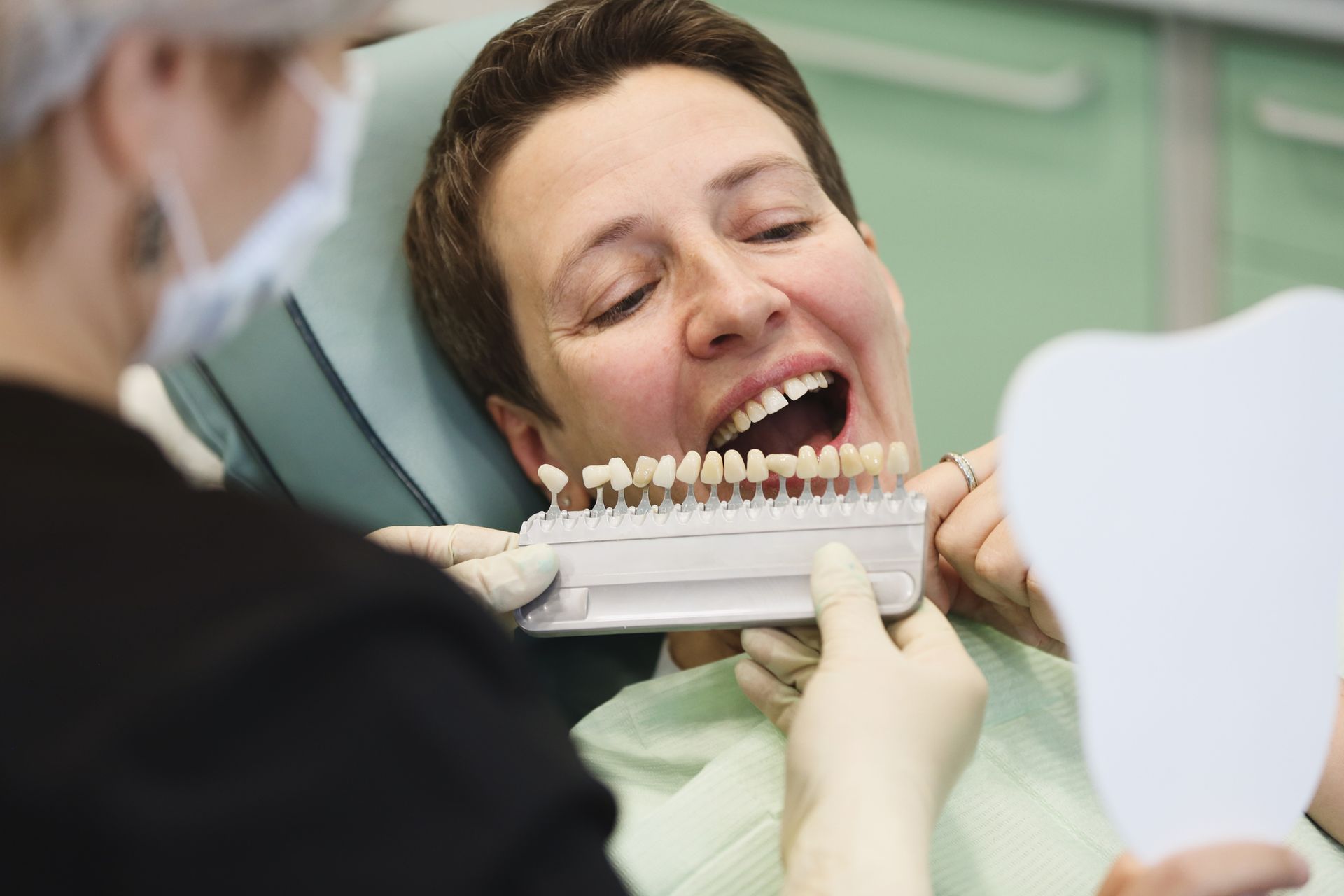 Dentist and patient selecting implant shade during a restorative dentistry consultation. 