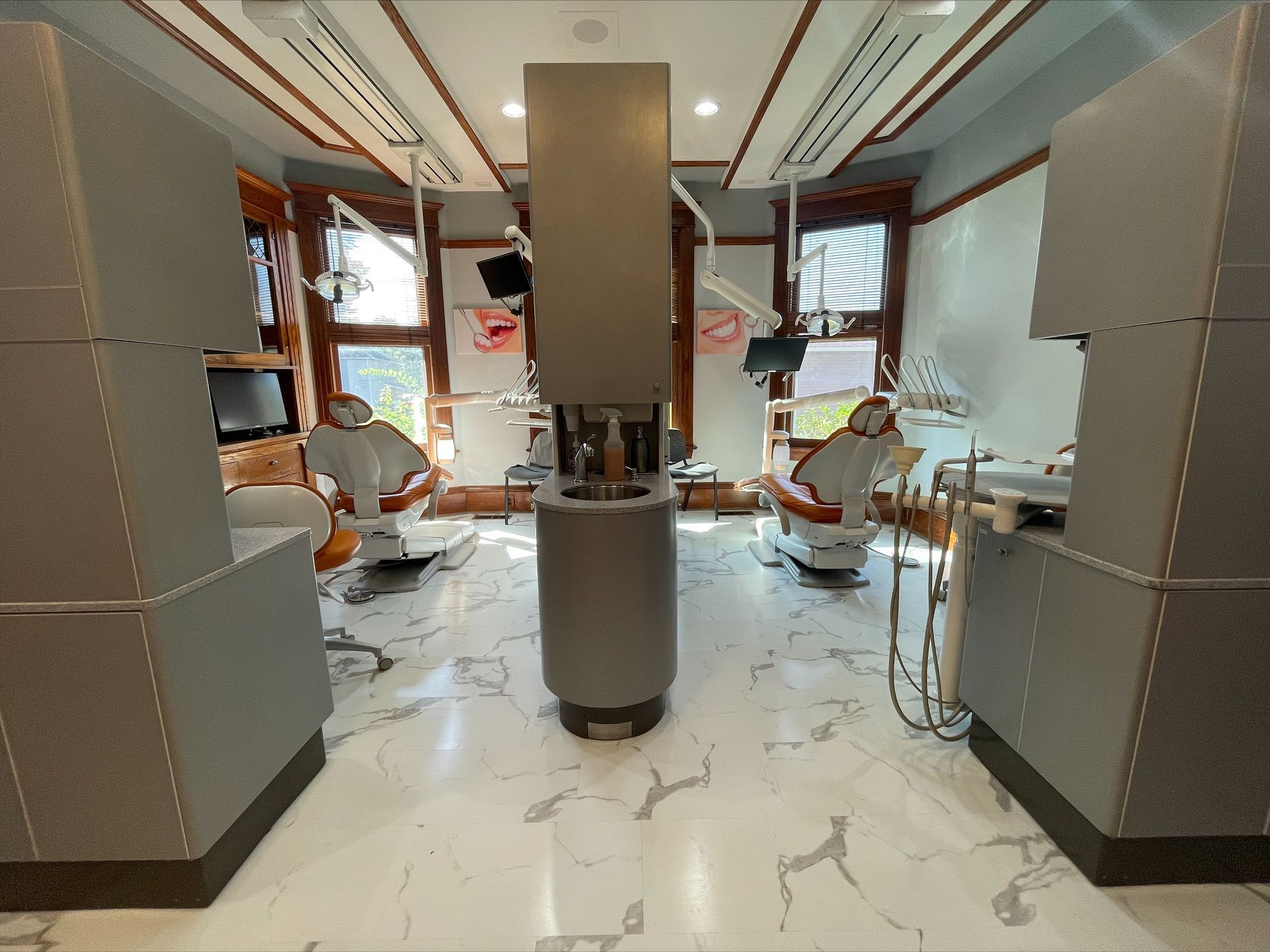 A dental office with two dental chairs and a sink