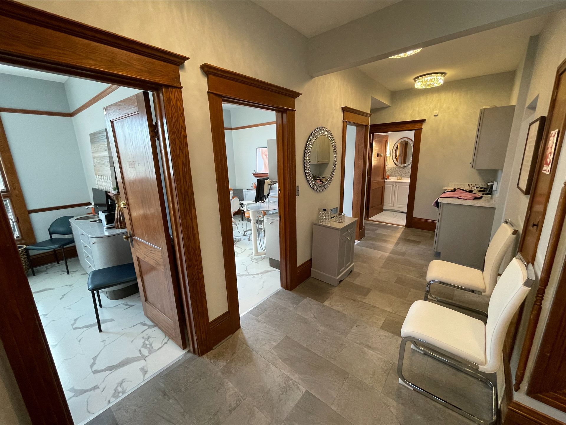 A hallway with chairs and a mirror in a dental office.