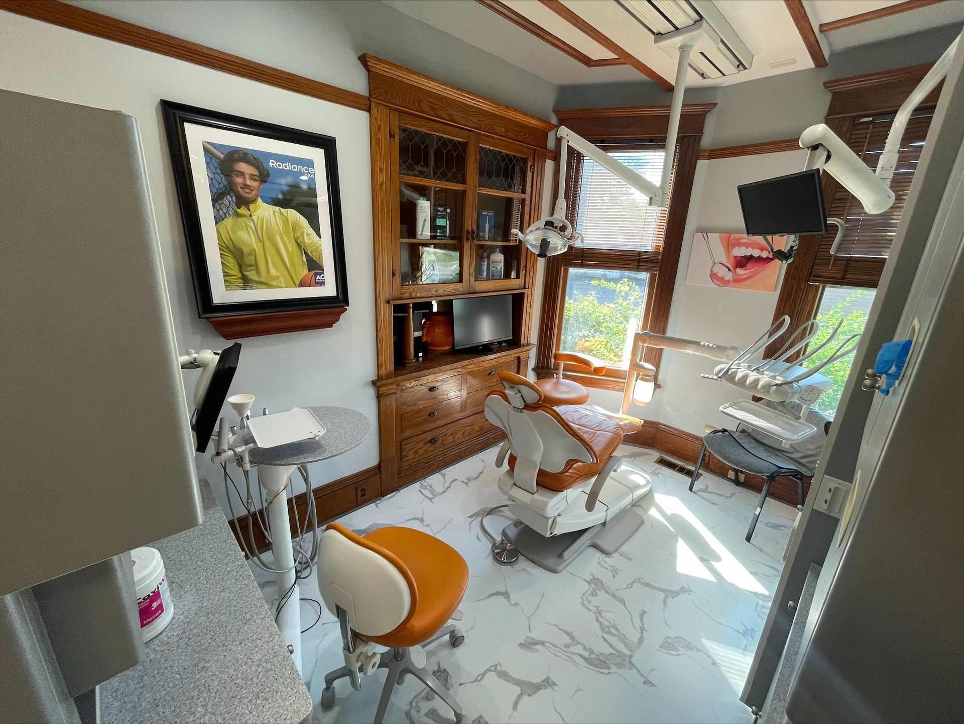 A dental office with a dental chair and a picture on the wall.