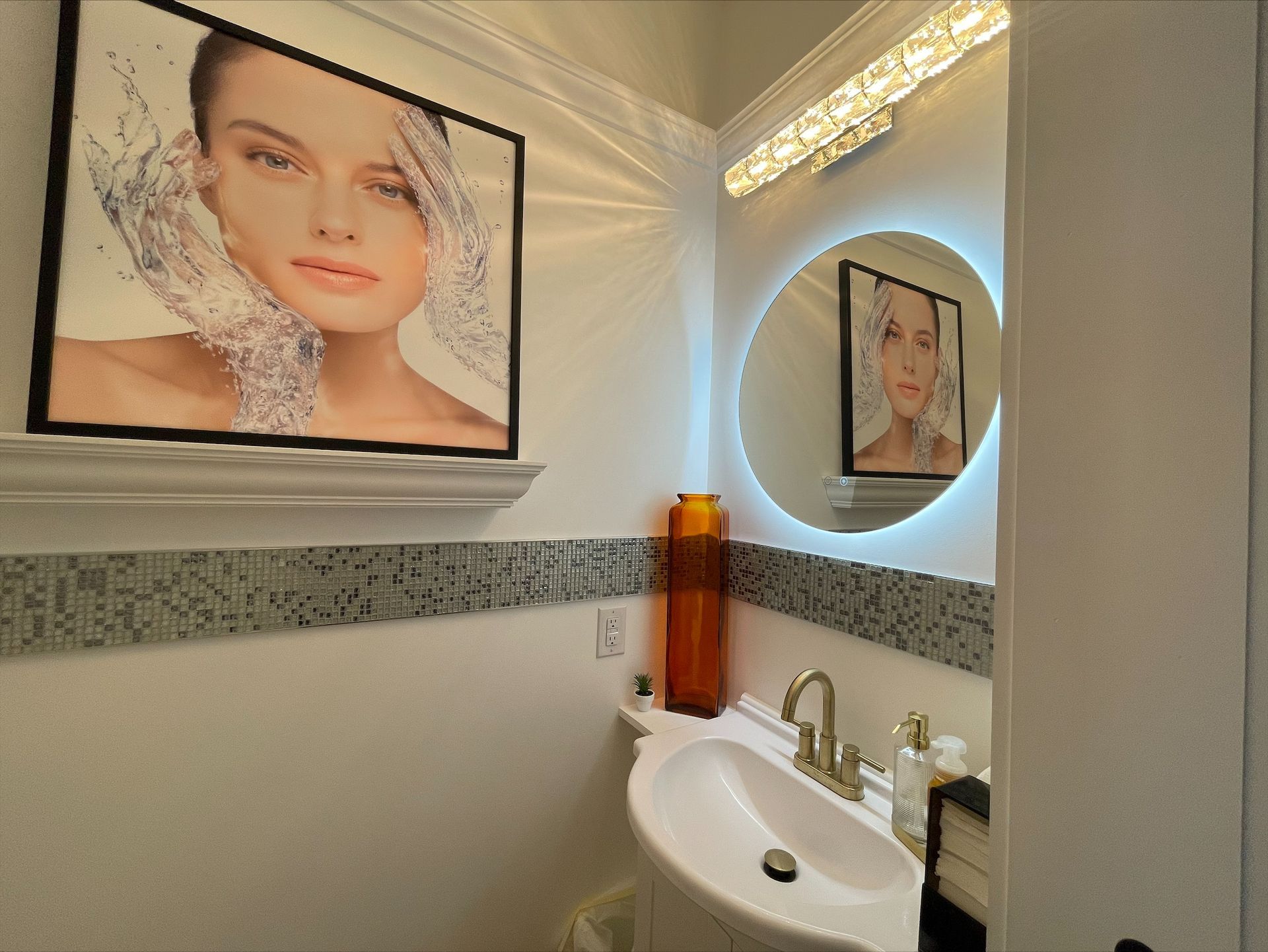 A bathroom with a sink and a picture of a woman on the wall