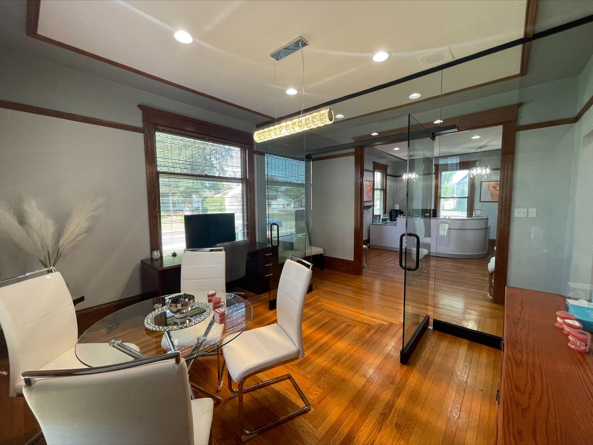 A dining room with a table and chairs and a glass door.