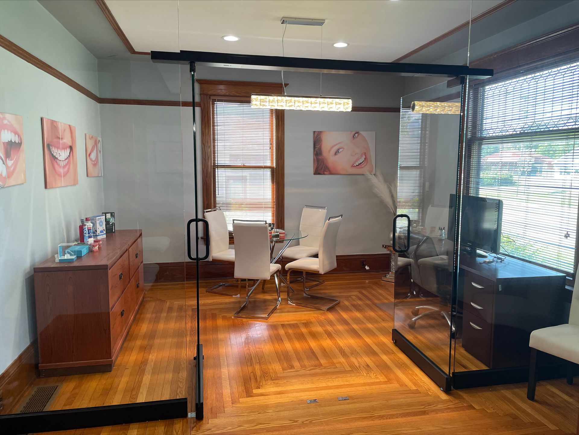 A dining room with a table and chairs and a glass wall.