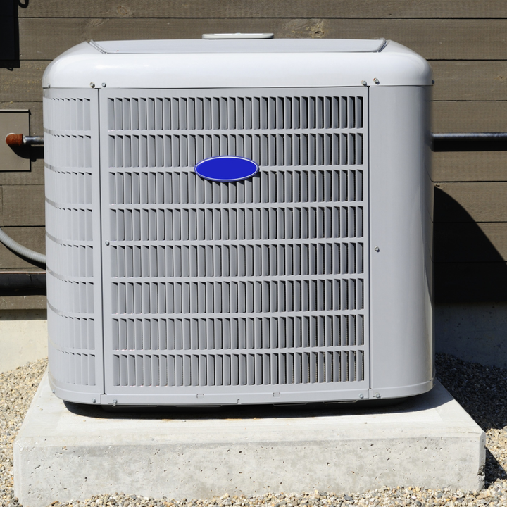 A carrier air conditioner is sitting on a concrete block