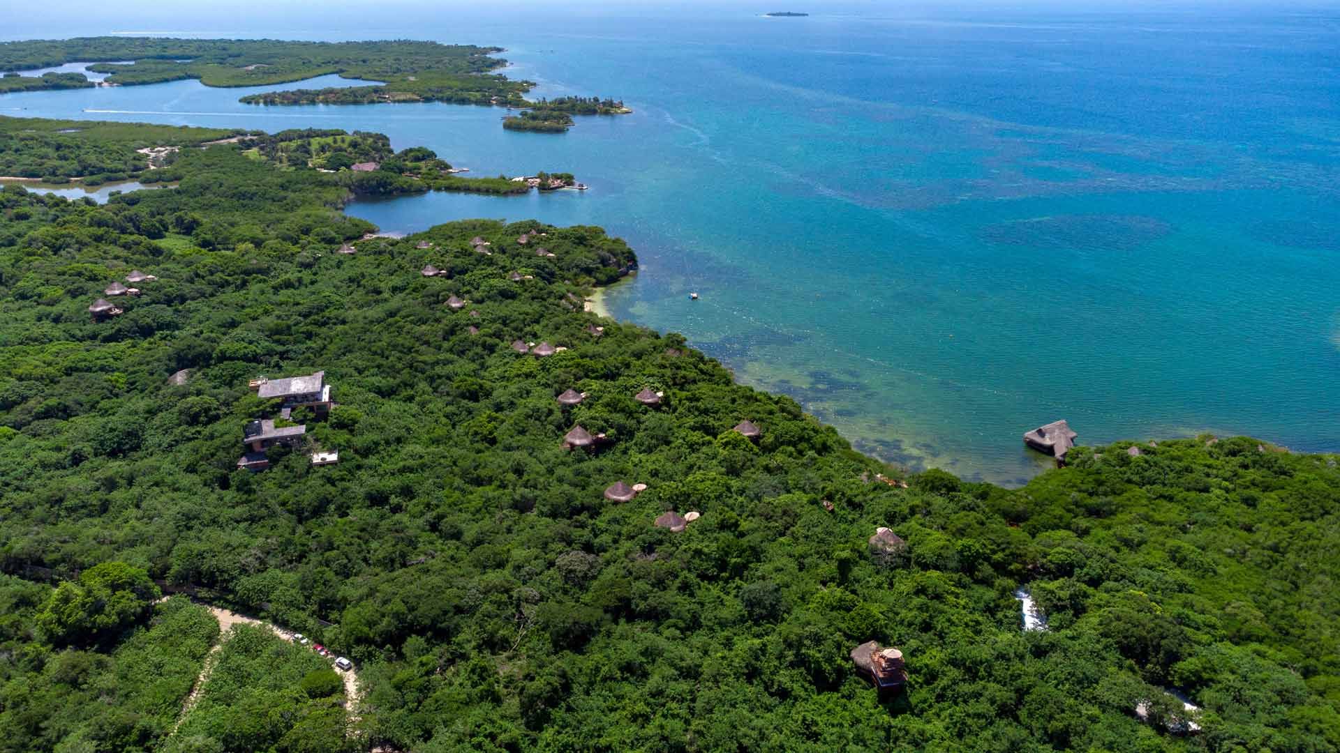 Vista aérea de bungalows rodeados de vegetación tropical y el mar Caribe en la isla de Barú, Hotel Las Islas