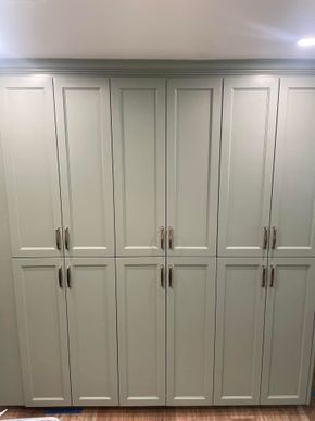 Built-in white kitchen cabinets with silver handles and decorative frosted glass panels