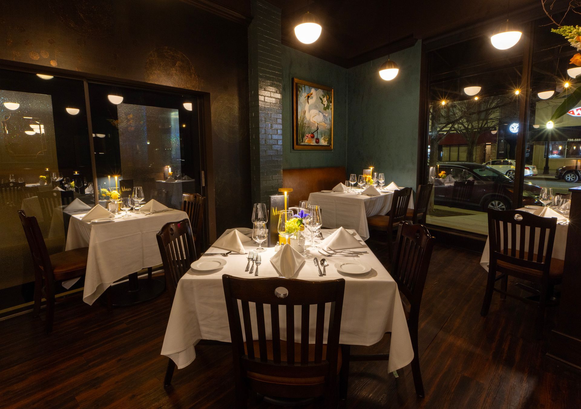 A dining room with tables and chairs and a large window.