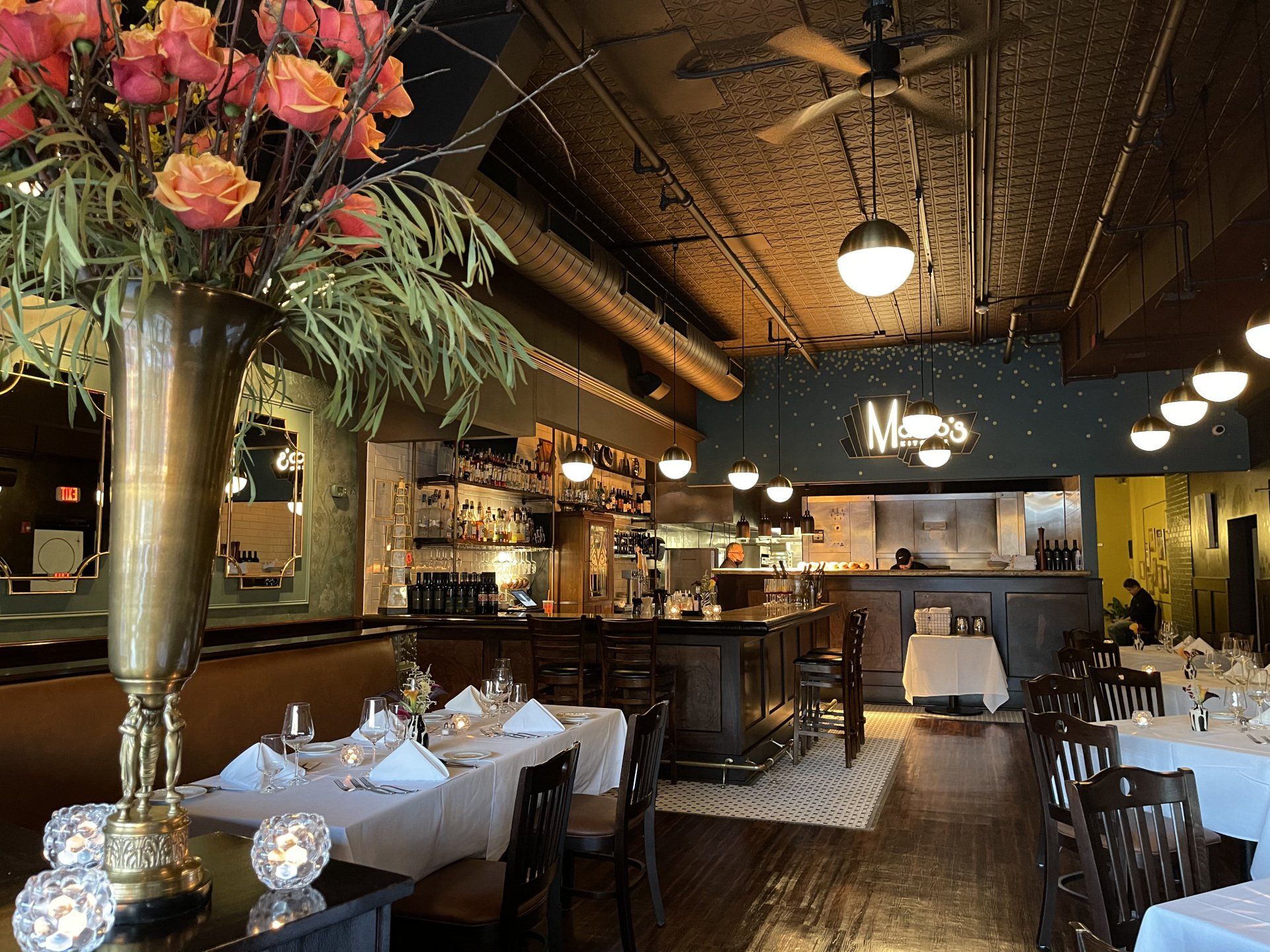A restaurant with tables and chairs and a vase of flowers