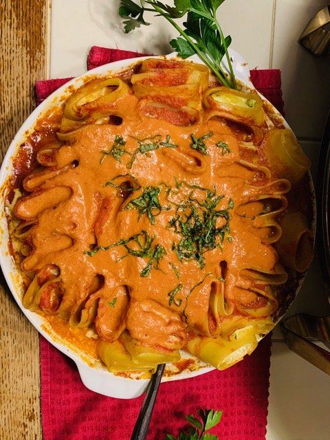 A casserole dish filled with pasta and sauce with a fork in it
