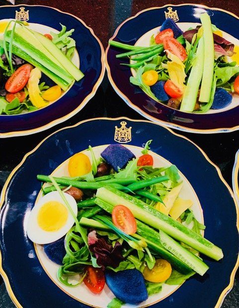 Three plates of salad with eggs and vegetables on a table