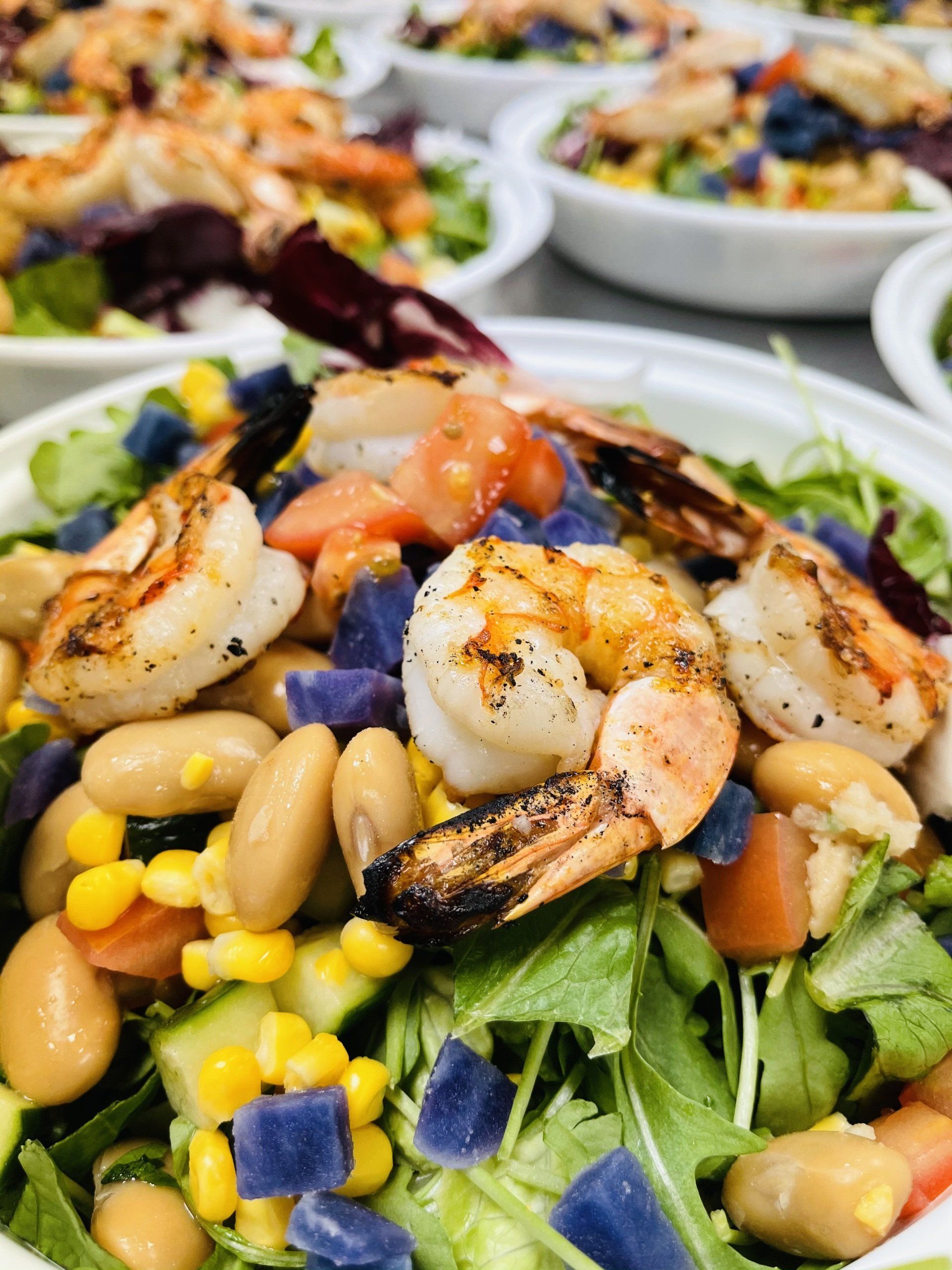 A close up of a salad with shrimp and beans