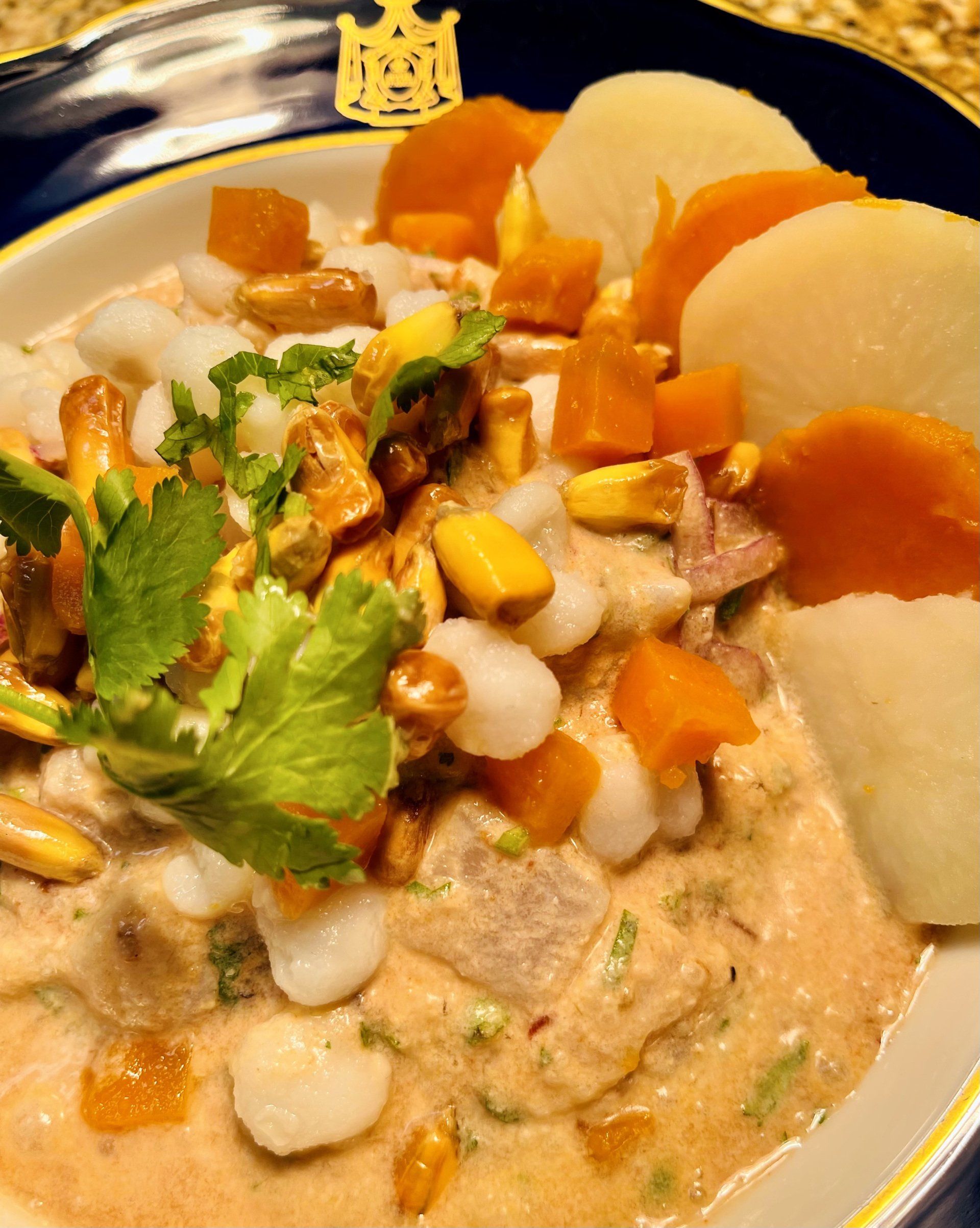 A close up of a plate of food with carrots and potatoes on a table.