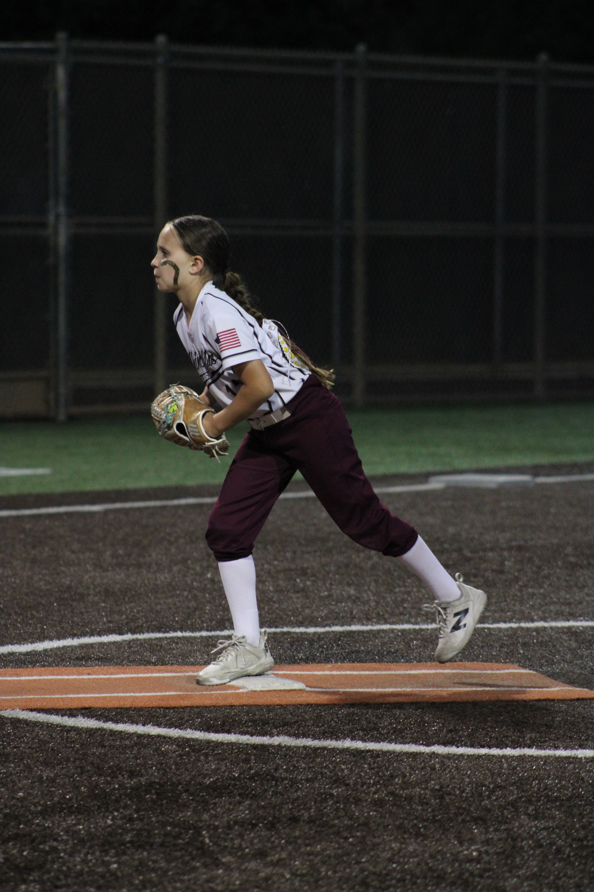 Baseball player sliding into base as another player attempts to catch the ball.