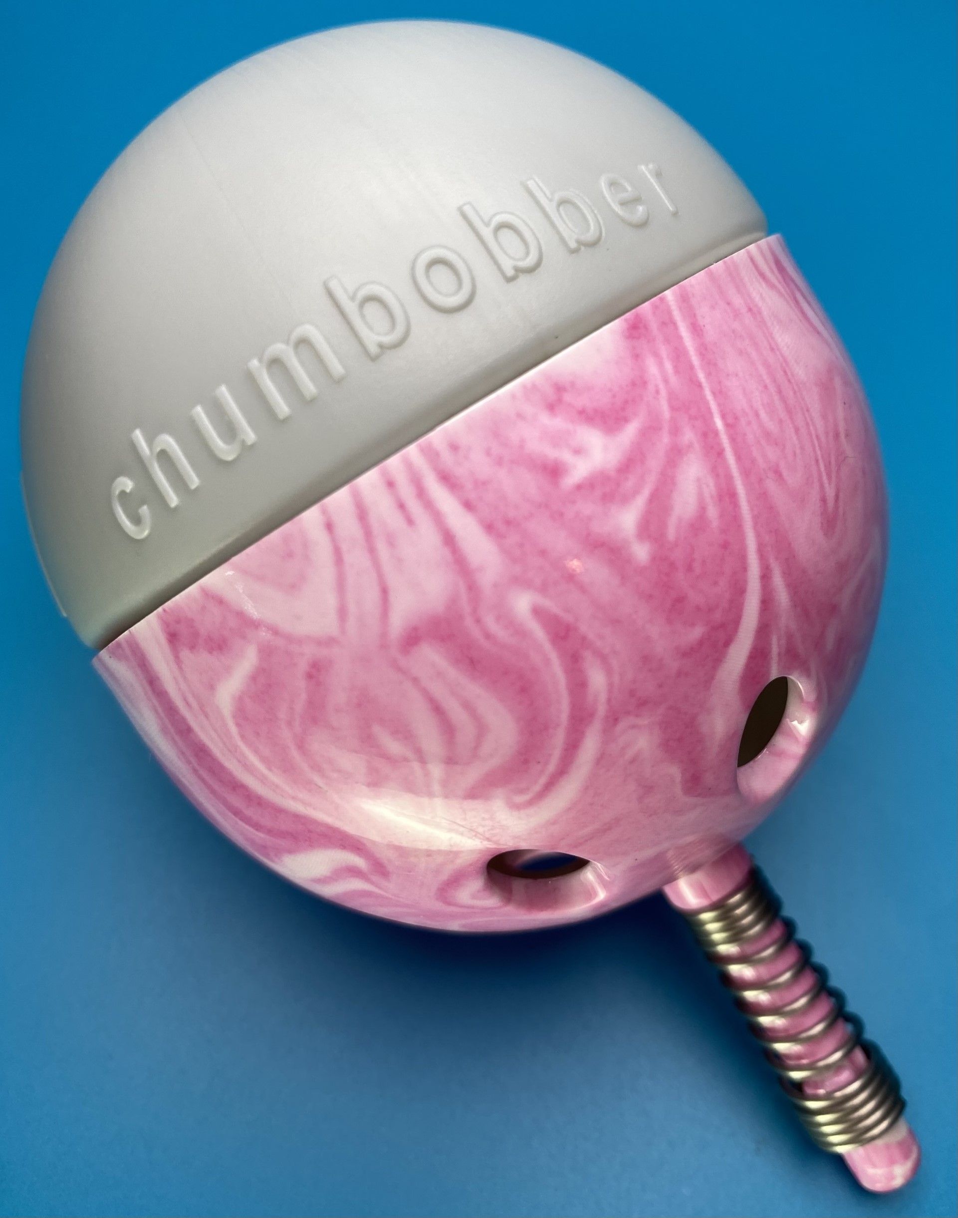 A pink and white chumbobber on a blue surface