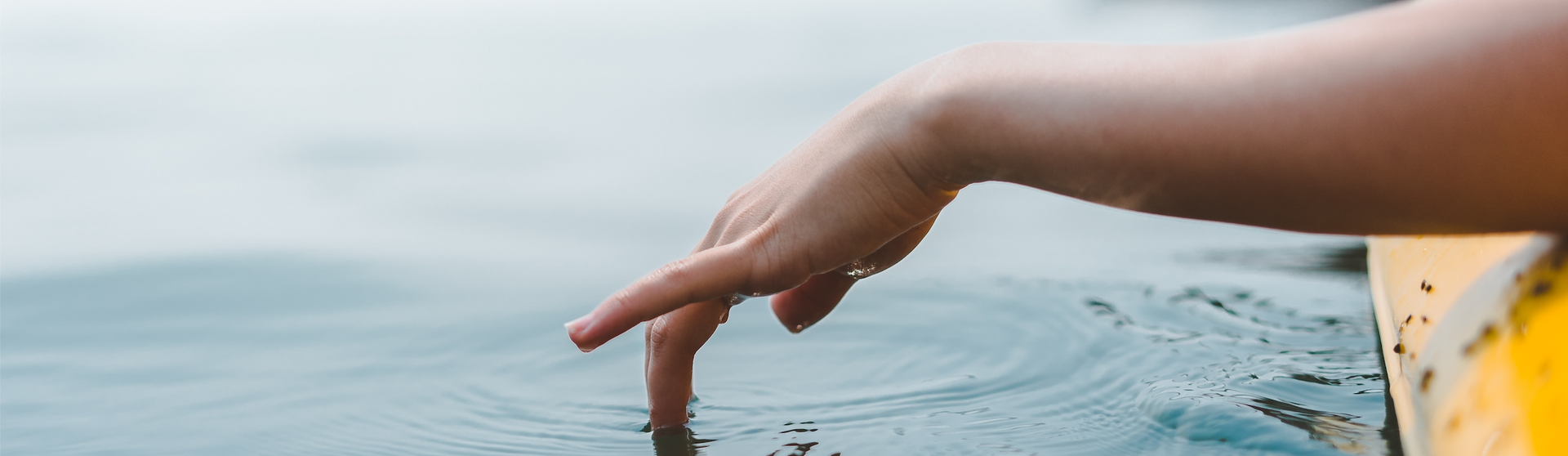 A person is touching the water with their finger.