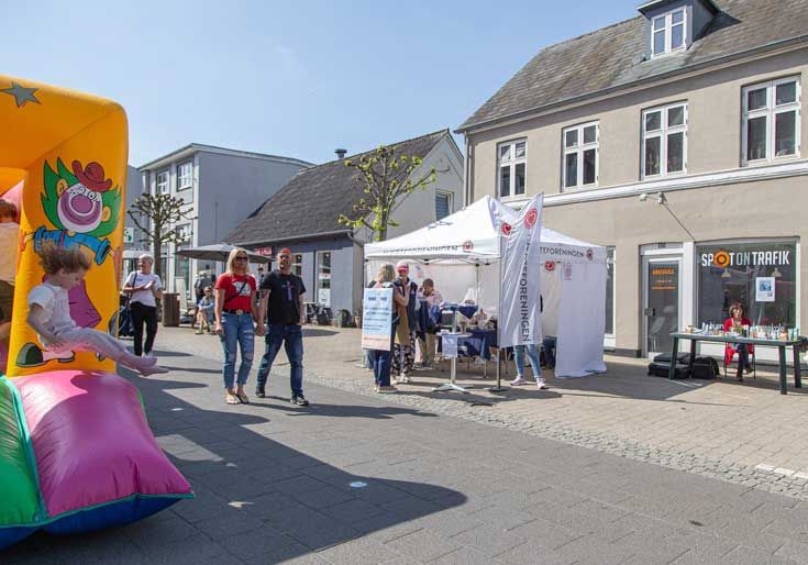 Gademarked med Røde Kors-telt, hoppeborg og gående mennesker.