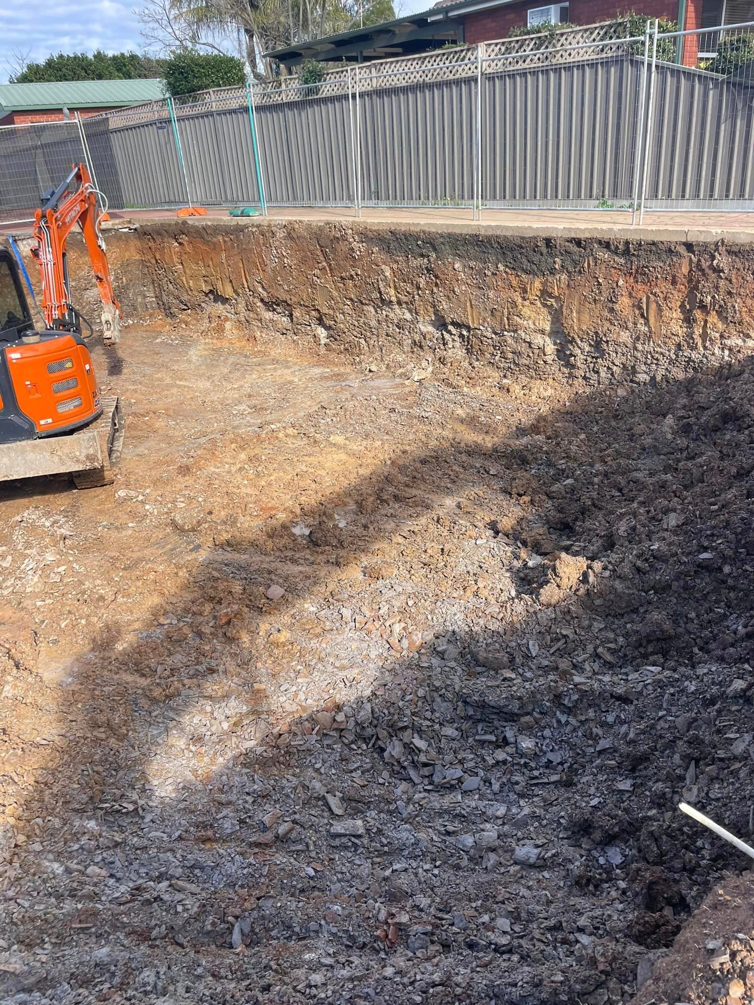 An excavator is digging a hole in the dirt in a construction site.