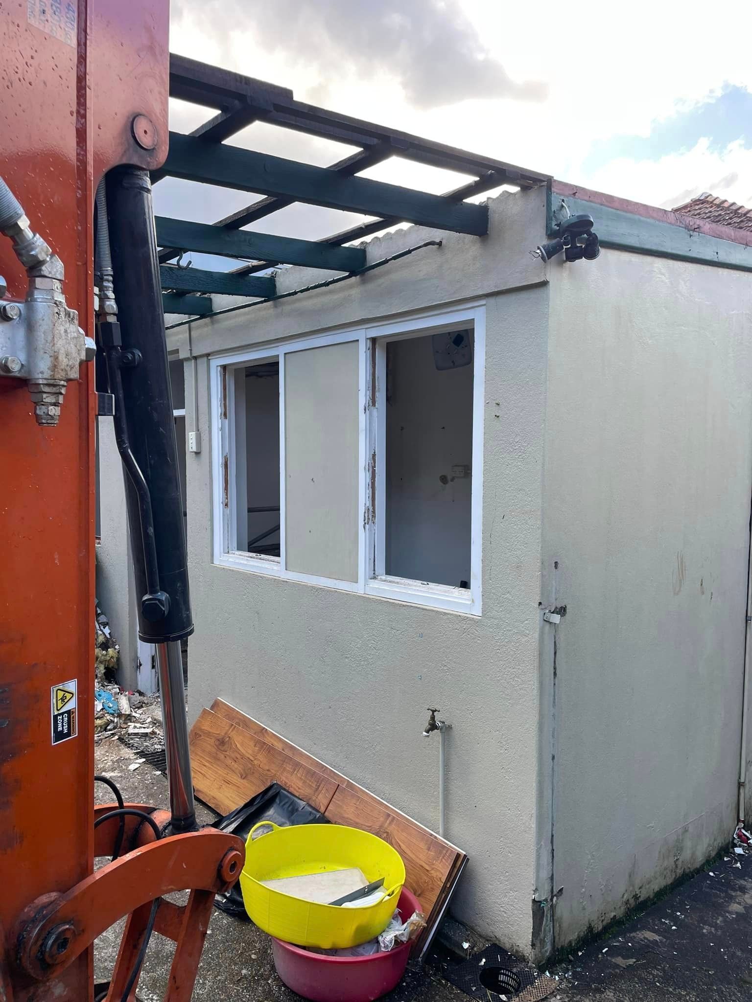 A yellow bowl is sitting in front of a building with a crane in the background.
