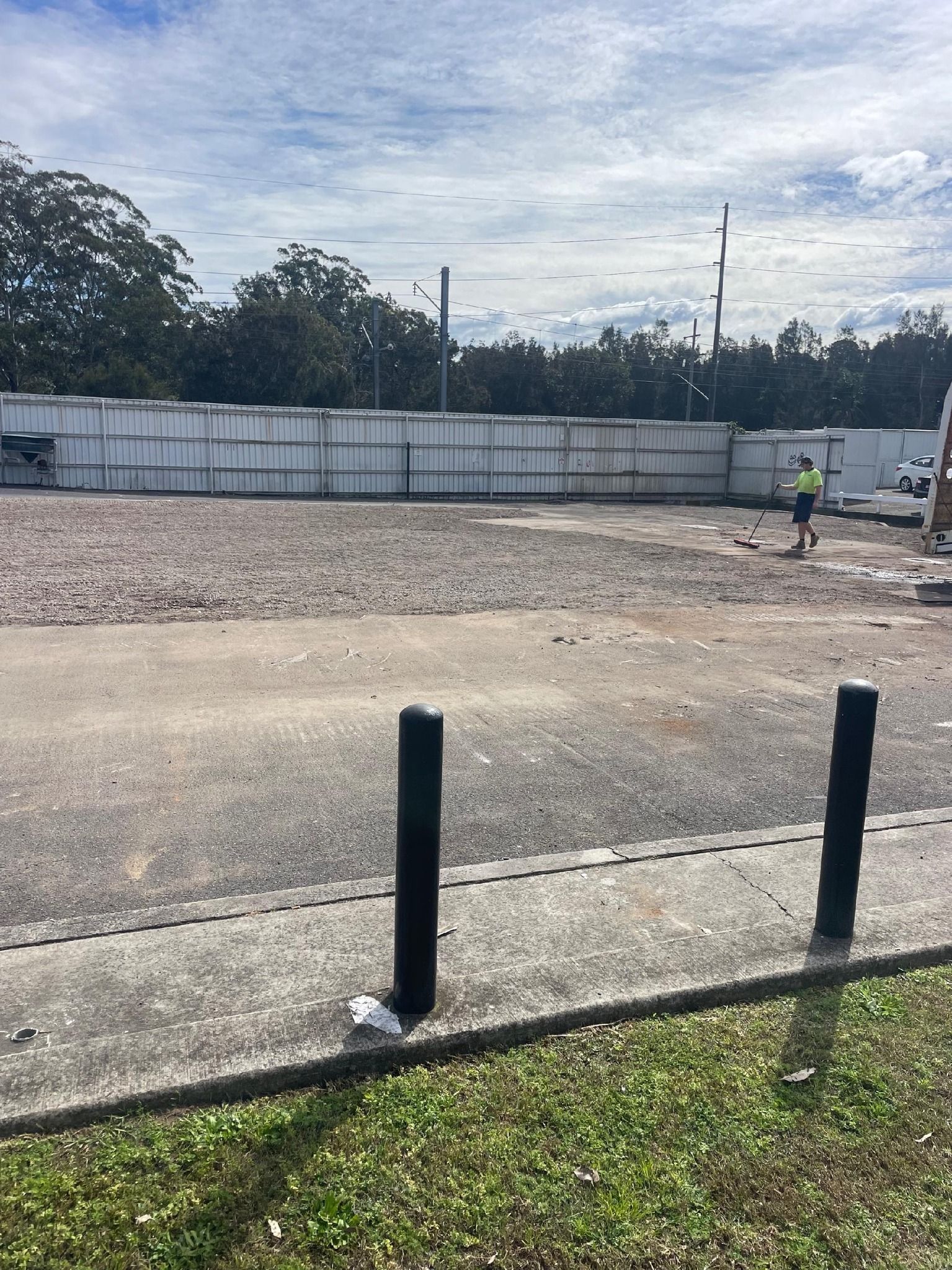A man in a yellow vest is working on a construction site.