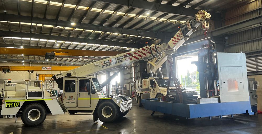 A Crane Lifting A Large Machine