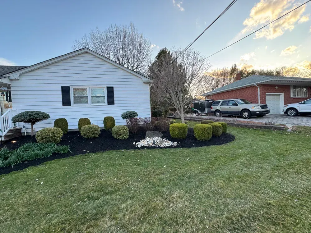 A white house with a lush green lawn in front of it.