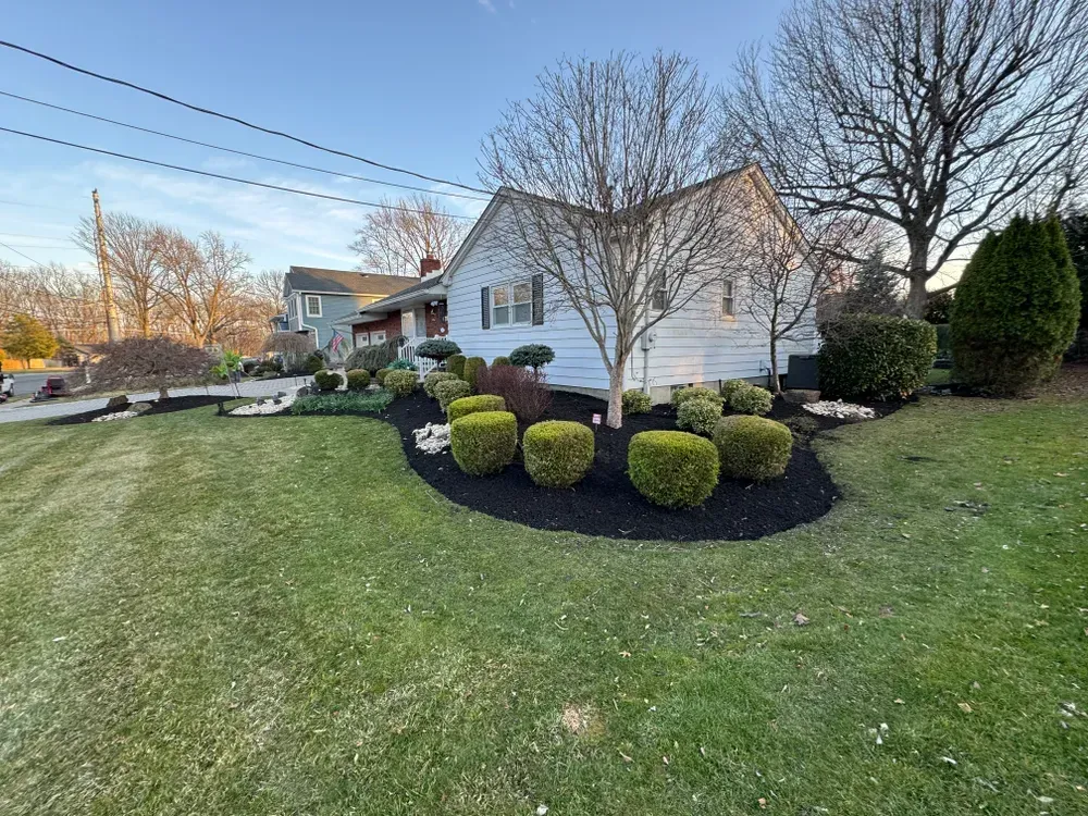 A white house with a lush green lawn in front of it.
