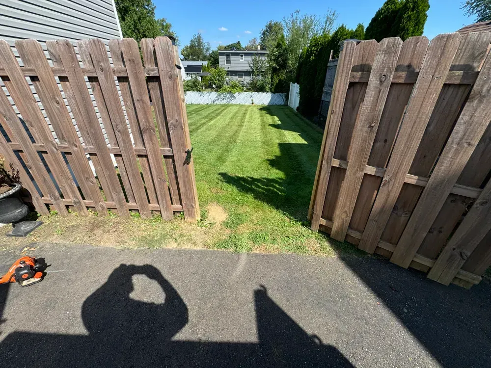 A wooden fence is surrounded by a lush green lawn.