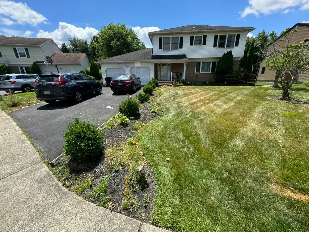 A black car is parked in front of a house.
