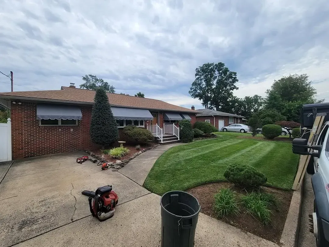 A lawn mower is sitting on the sidewalk in front of a house.
