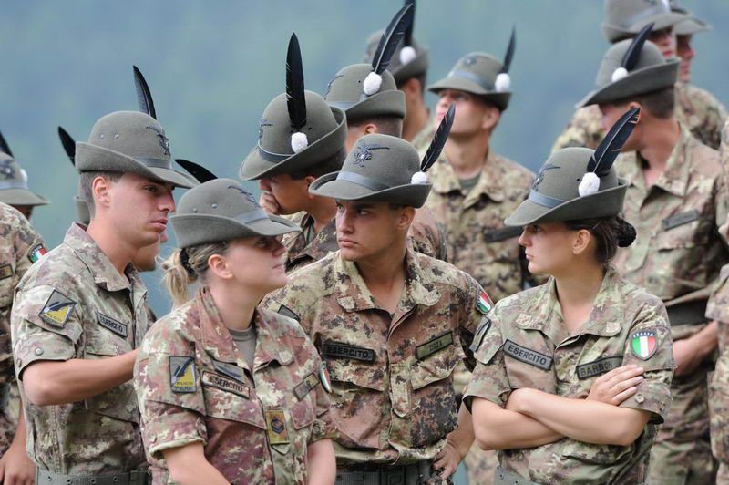 Alpini in divisa con cappello tradizionale durante un momento conviviale all’Aperitivo con gli Alpini a Châtillon, tra sorrisi e brindisi.