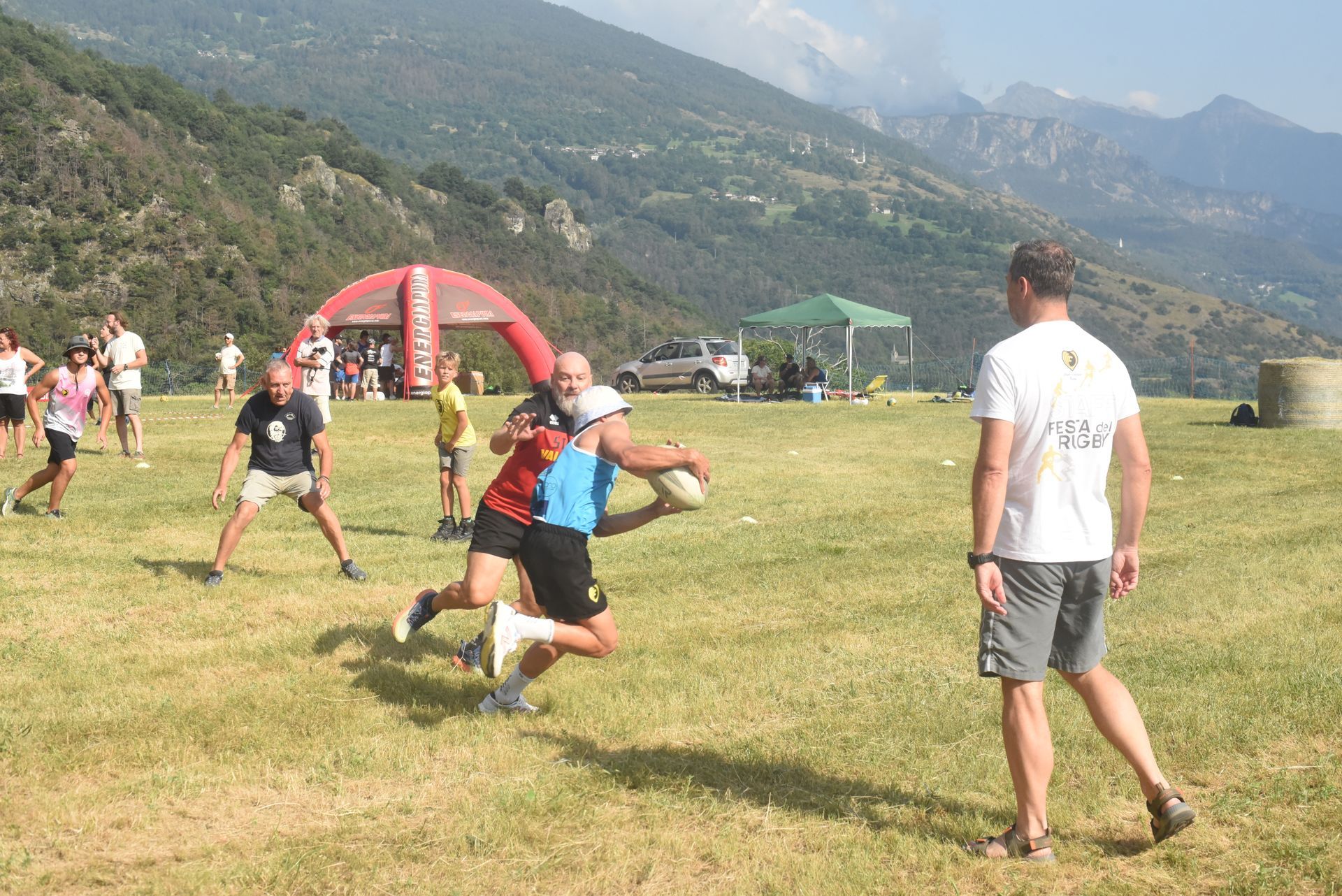 Momento di gioco del torneo di rugby al Pekelin Strong Music Fest, con squadre amatoriali in campo e pubblico a bordo campo