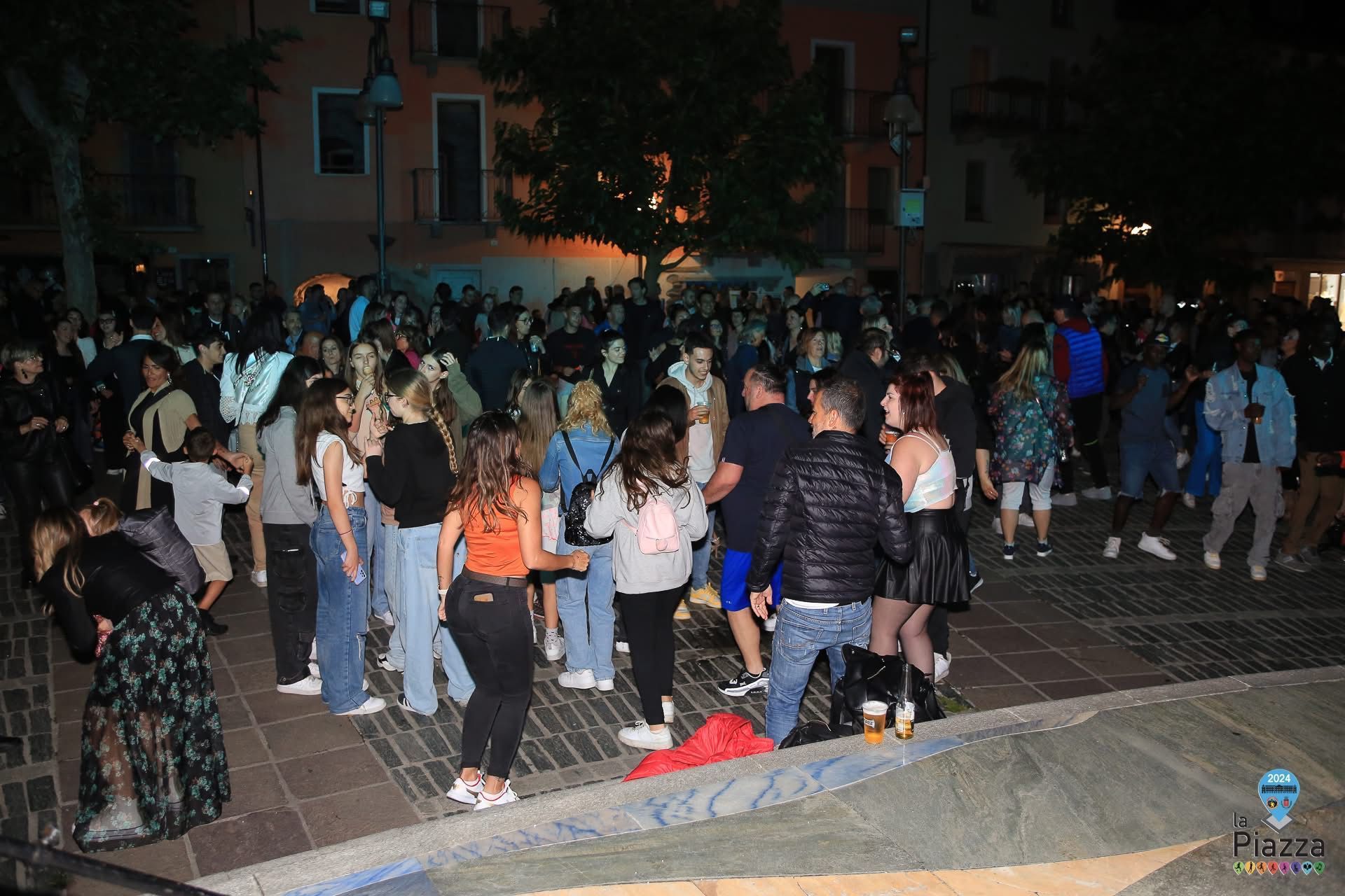 Piazza animata da una serata danzante a Saint-Vincent, con musica coinvolgente e luci colorate sul palco