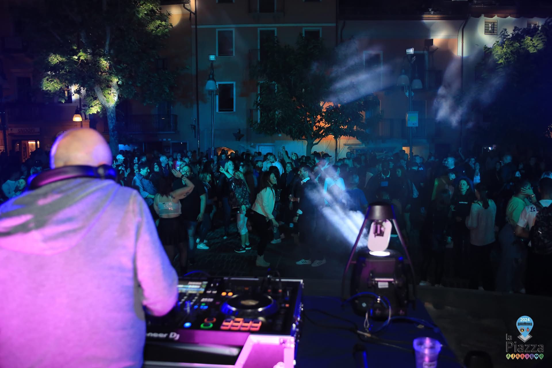 DJ set dal vivo nella piazza centrale di Saint-Vincent, tra luci, musica e pubblico in festa durante una serata estiva
