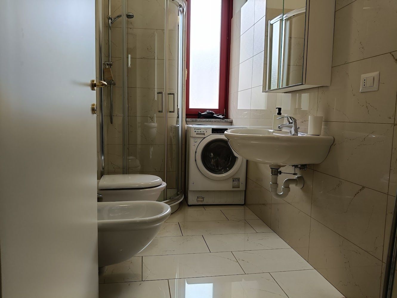Salle de bain lumineuse avec douche et lave-linge séchant
