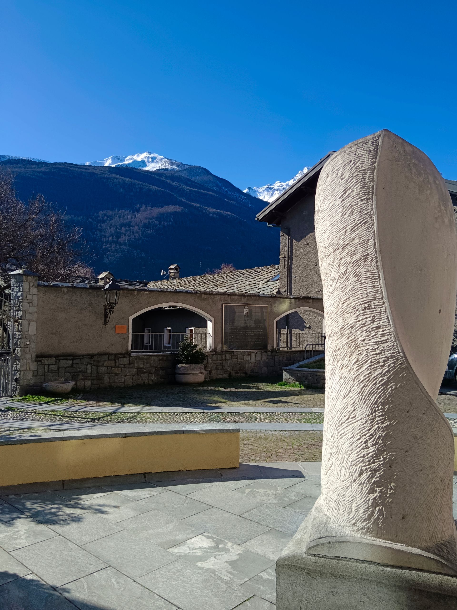 Statua in pietra nel cuore del borgo di Châtillon, testimonianza artistica e culturale della tradizione valdostana
