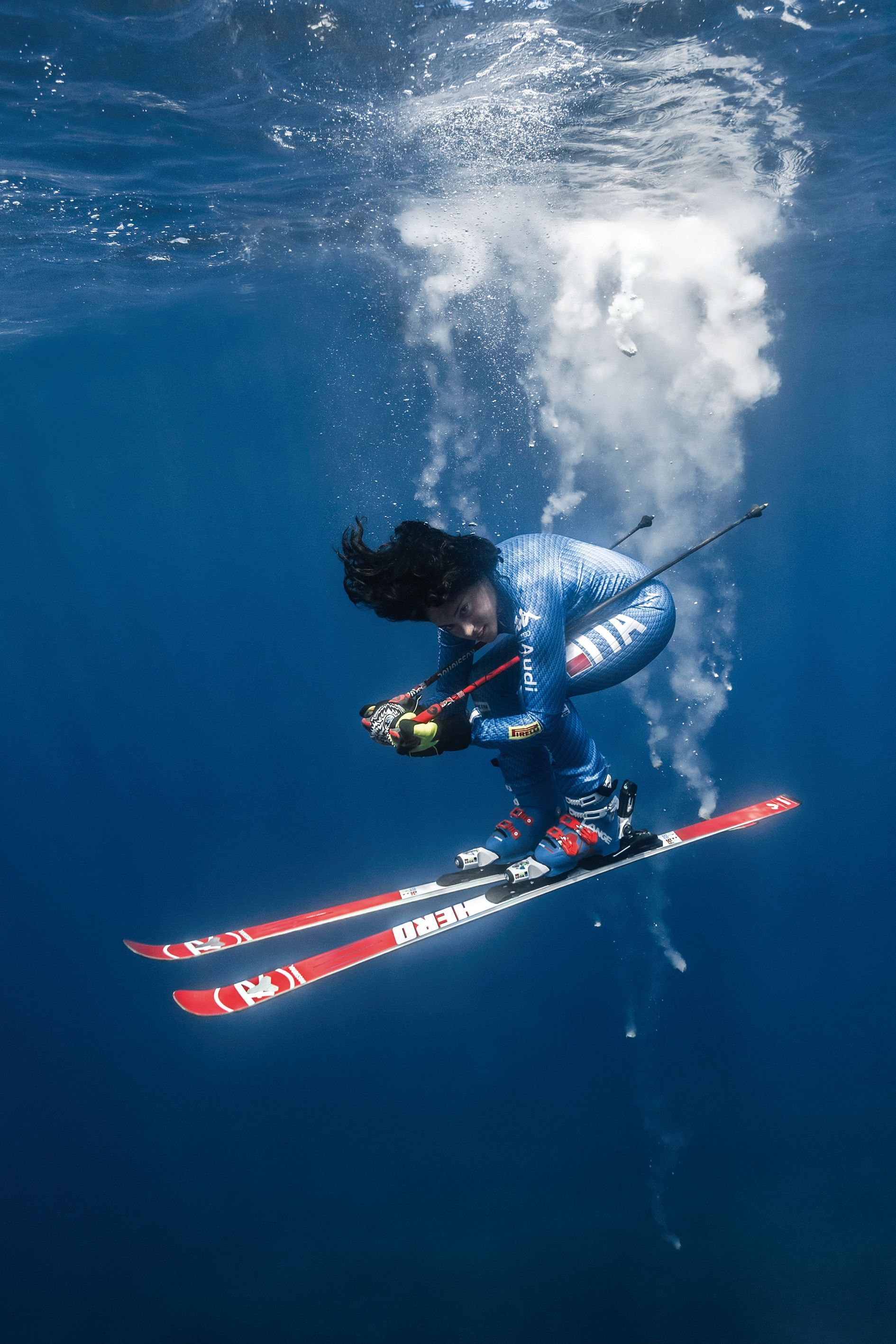 Federica Brignone immersa nel mare di Lipari con gli sci ai piedi, metafora visiva dell’interconnessione tra sport e ambiente – foto di Giuseppe La Spada.