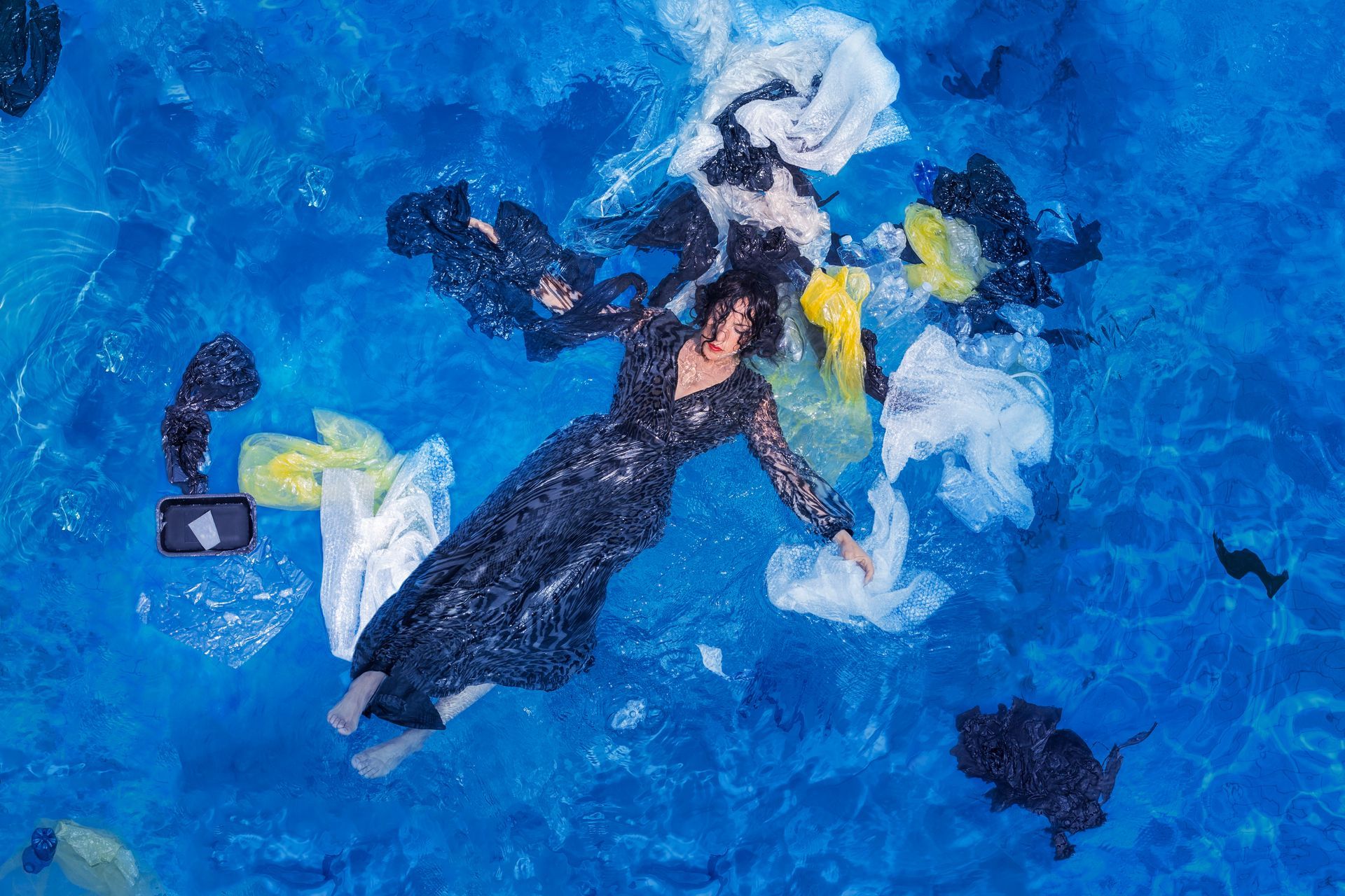 Federica Brignone in posa simbolica nell’acqua, circondata da plastica galleggiante per denunciare l’inquinamento degli oceani – foto di Giuseppe La Spada.