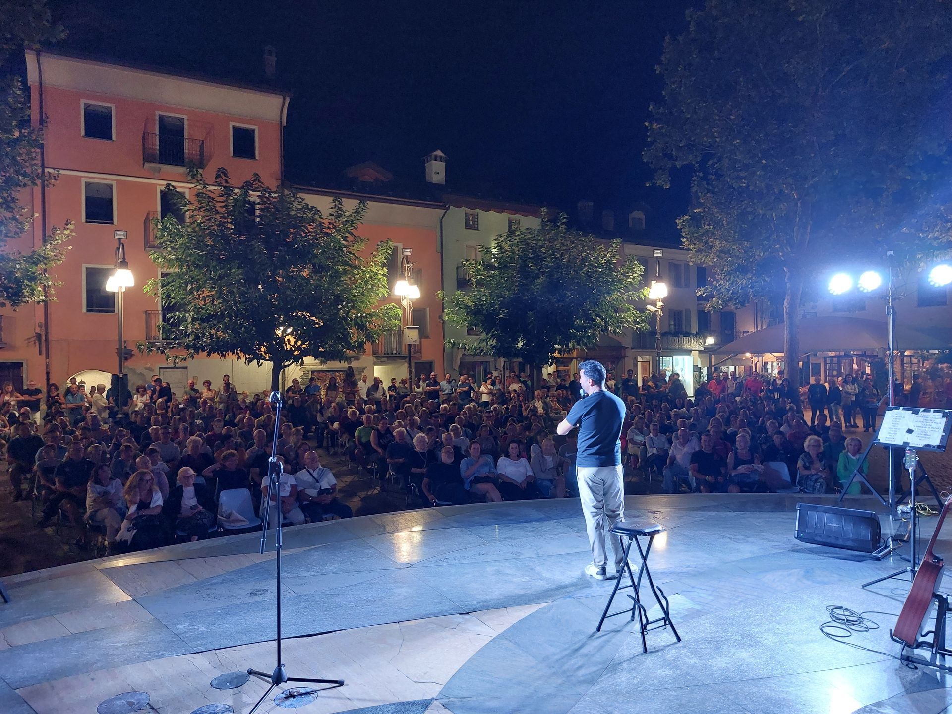 Pubblico entusiasta durante uno spettacolo comico a Saint-Vincent nell’estate 2024, in piazza gremita sotto le stelle.