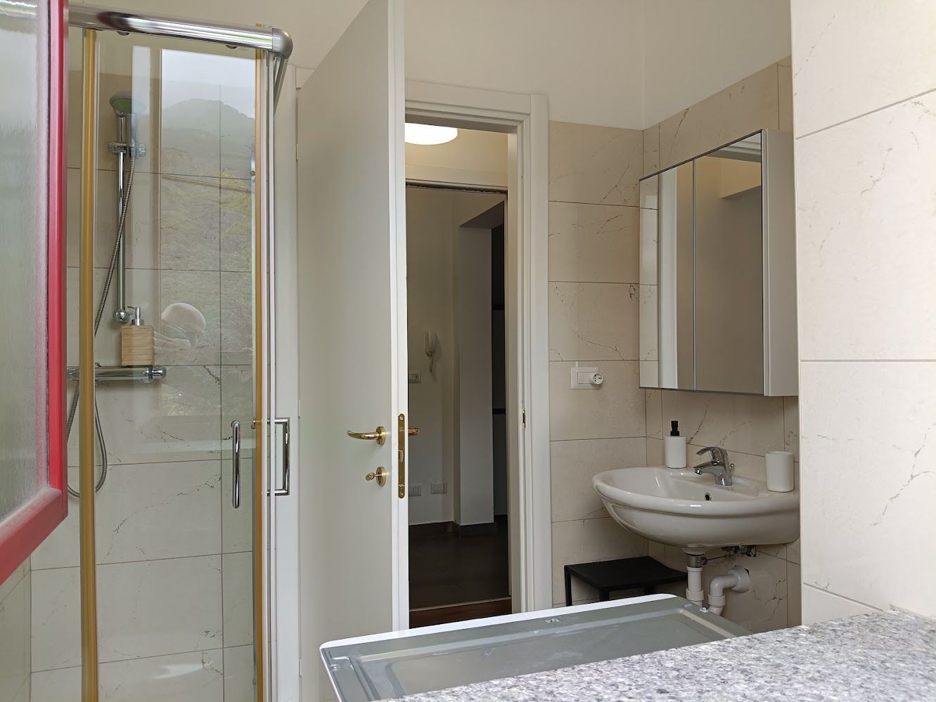 Petite salle de bain avec douche et lave-linge séchant