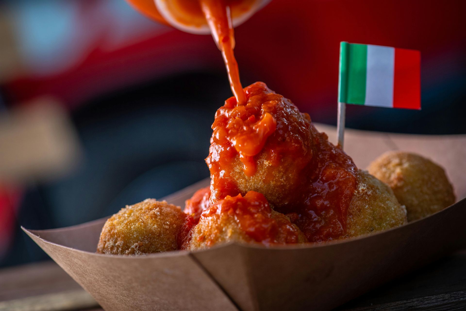 Primo piano di arancini dorati e croccanti, specialità siciliana servita al Vuccirria Street Food Festival di Châtillon