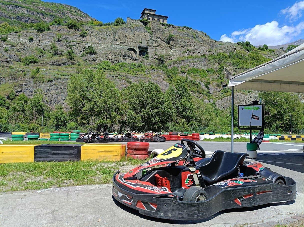 ❄️ Go-kart alla pista La Quercia 58 con vista sul Castello Gamba e montagne valdostane in autunno e inverno.