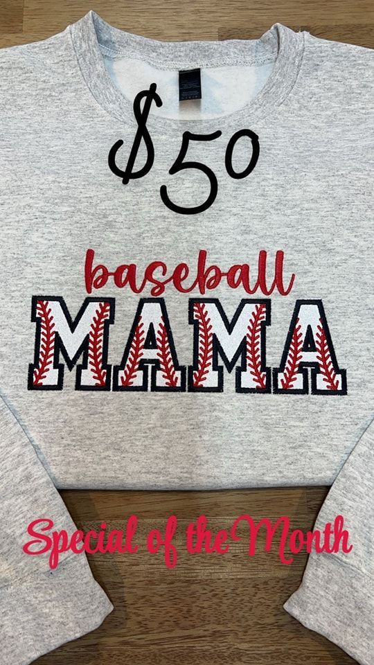 A baseball mama sweatshirt is sitting on a wooden table.