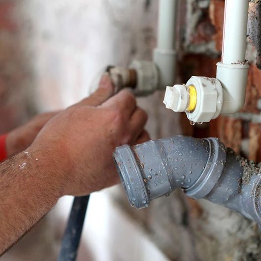 Plumber Working on Pipes — Plainview, NY — Martino Plumbing & Heating INC. Plumber Working on Pipes — Plainview, NY — Martino Plumbing & Heating INC.