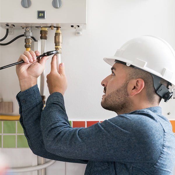 Repairman Installing a Natural Gas Boiler — Plainview, NY — Martino Plumbing & Heating INC. Repairman Installing a Natural Gas Boiler — Plainview, NY — Martino Plumbing & Heating INC.