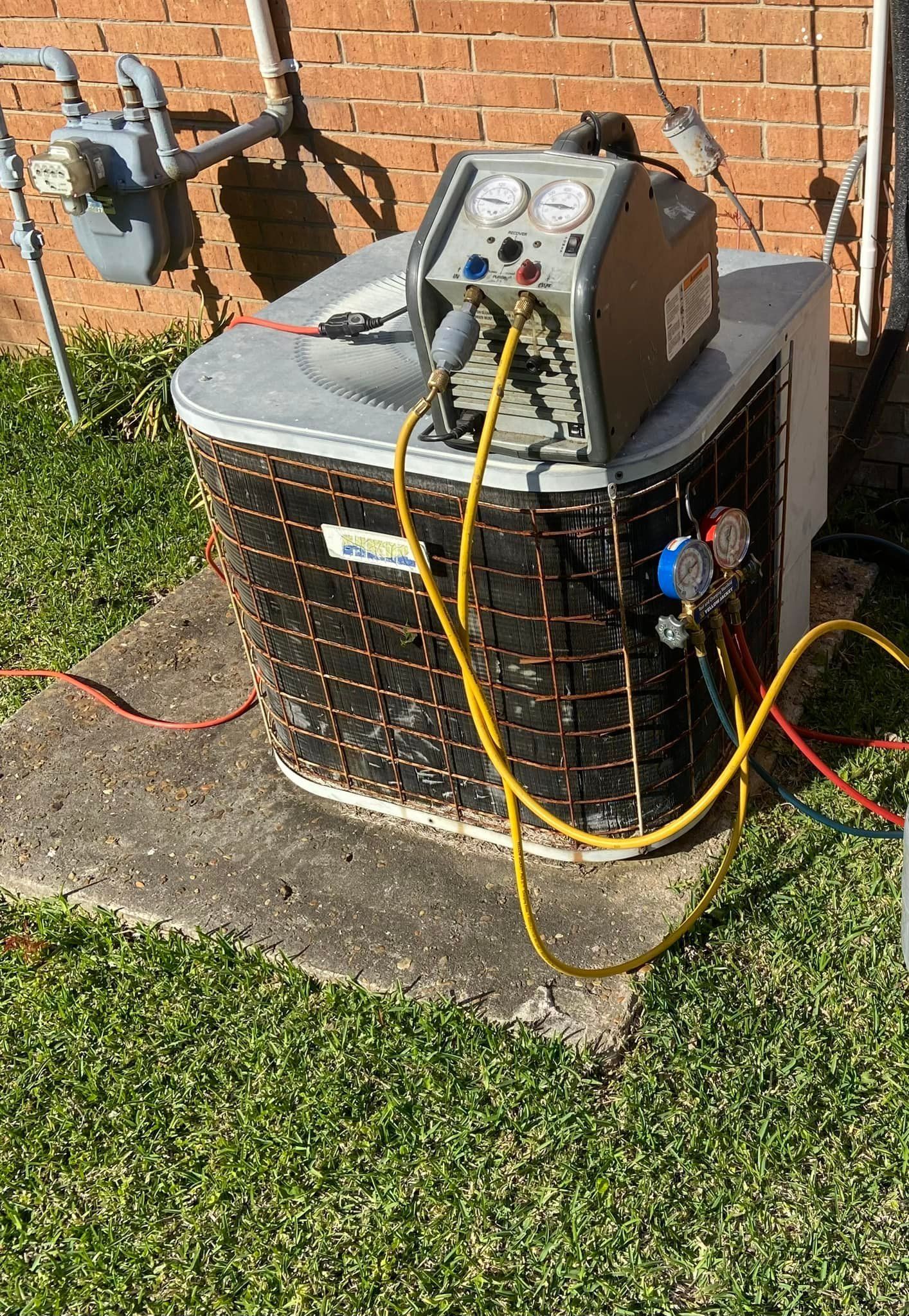 A white air conditioner installed within a dark wooden cabinet, above a flat screen television.